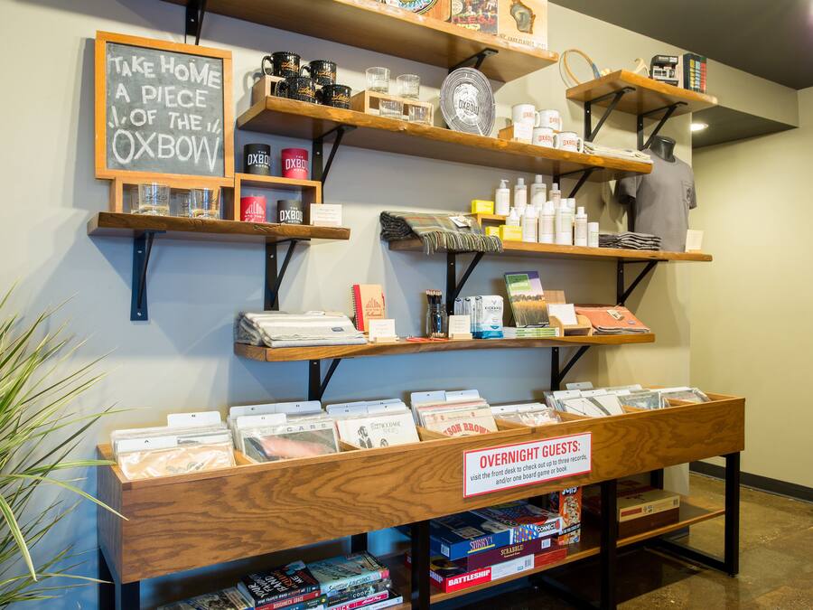 A store with shelves displaying mugs, books, and other items. There is a sign that says "Take home a piece of the oxbow."