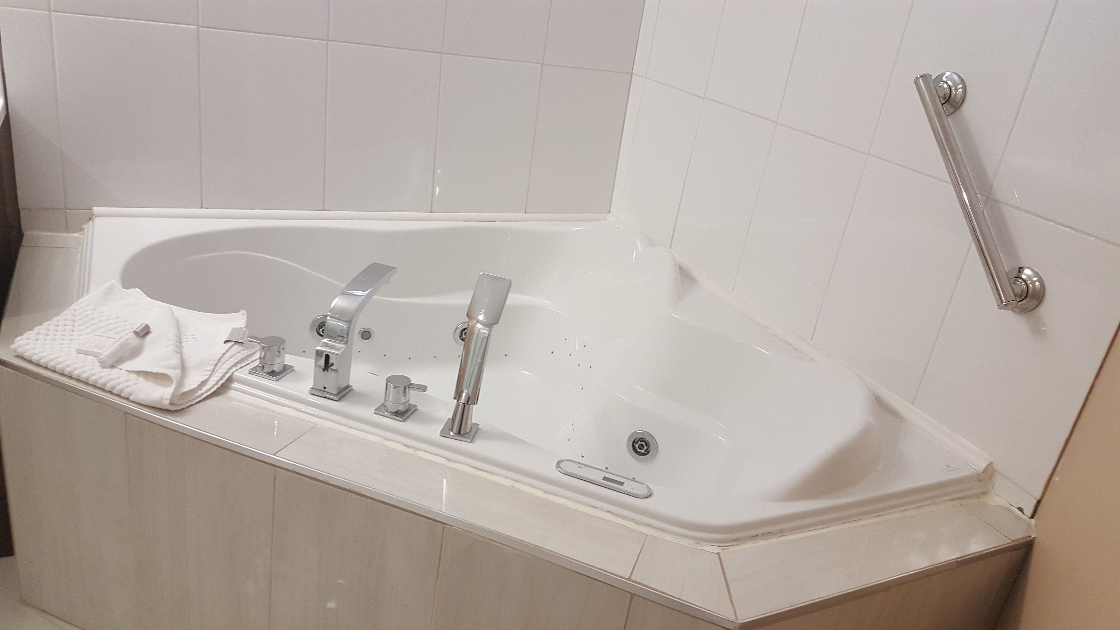 A modern bathroom with a freestanding bathtub, a handheld showerhead, and a towel rack.