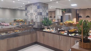 A buffet area with various food items and a decorative pillar. - L'Acordes Hotel (Porto Velho)