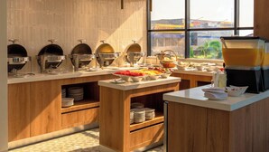 Cocina moderna con un montaje tipo bufé, armarios de madera y un amplio ventanal con vistas al exterior.