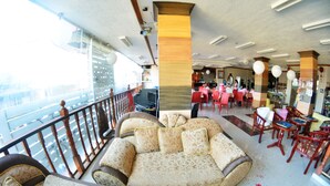 A spacious lounge area with a large sofa, multiple chairs, and a bar area. - Honey Hunt House (Cebu City)