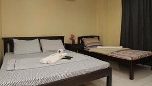 A hotel room with a large bed, a smaller bed, a nightstand, and a window with curtains. - Honey Hunt House (Cebu City)