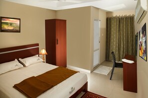 Une chambre d’hôtel comprenant un lit, une armoire, un bureau et une salle de bain.