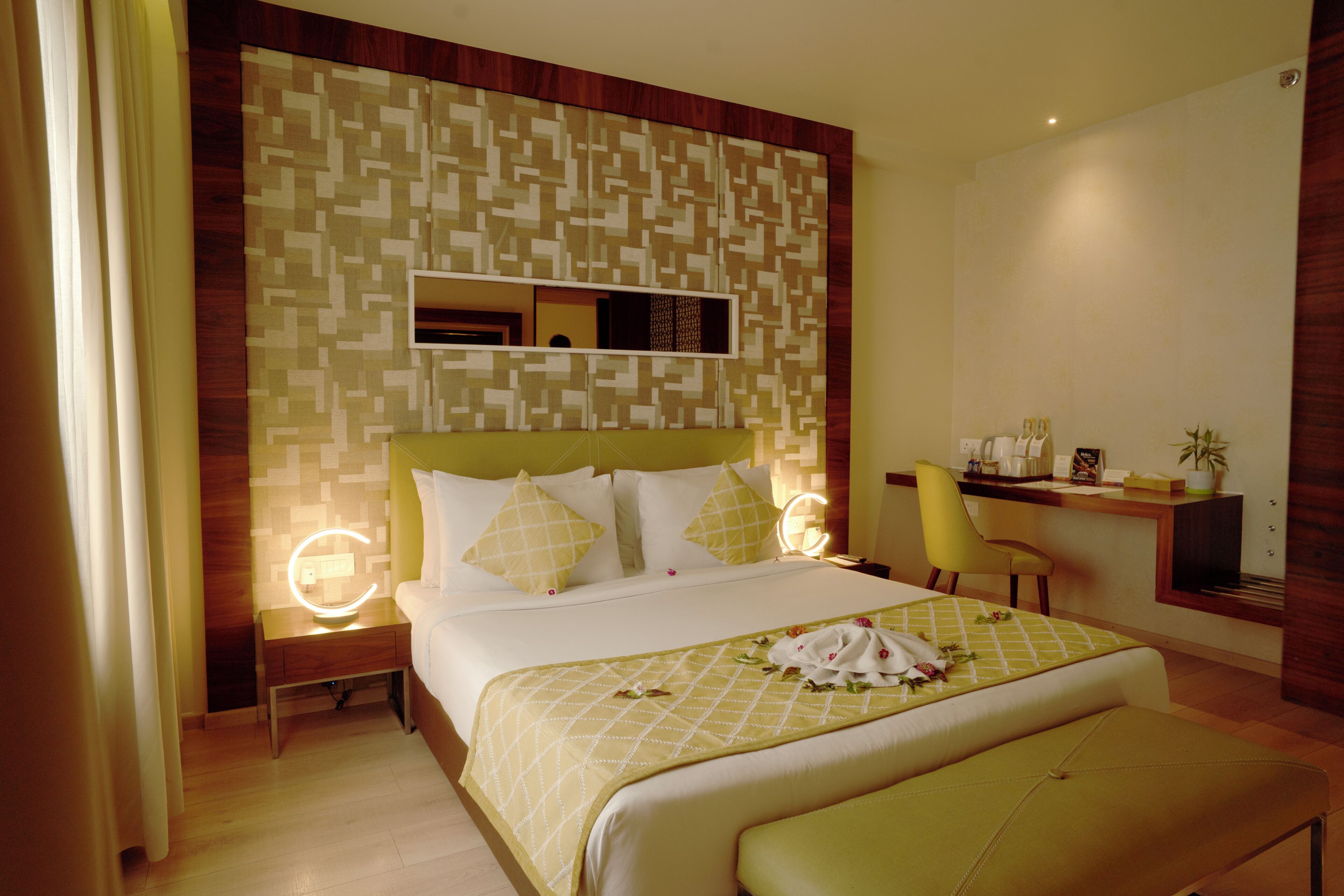 Een hotelkamer met een groot bed, een bureau, een stoel en een nachtkastje.