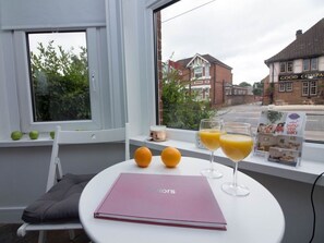 A table with a pink folder, two oranges, and two glasses of orange juice.