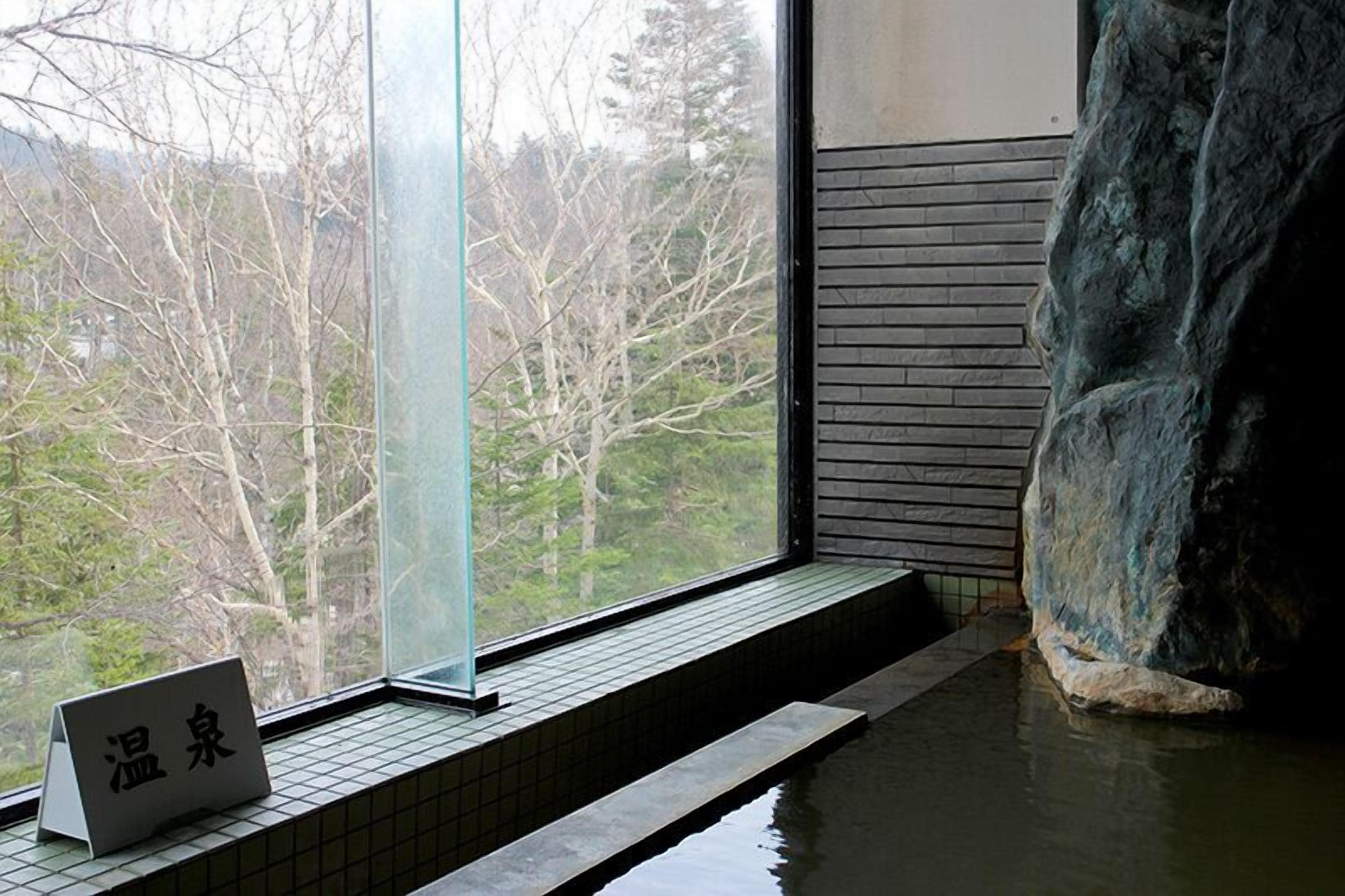 A spa area with a large rock, a window with a view of trees, and a sign with Chinese characters.