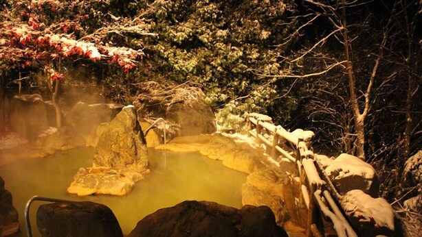 A hot spring area with rocks and a wooden fence. - Aonobi Yuyu (Biei)