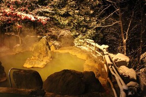 A hot spring area with rocks and a wooden fence. - Aonobi Yuyu (Biei)
