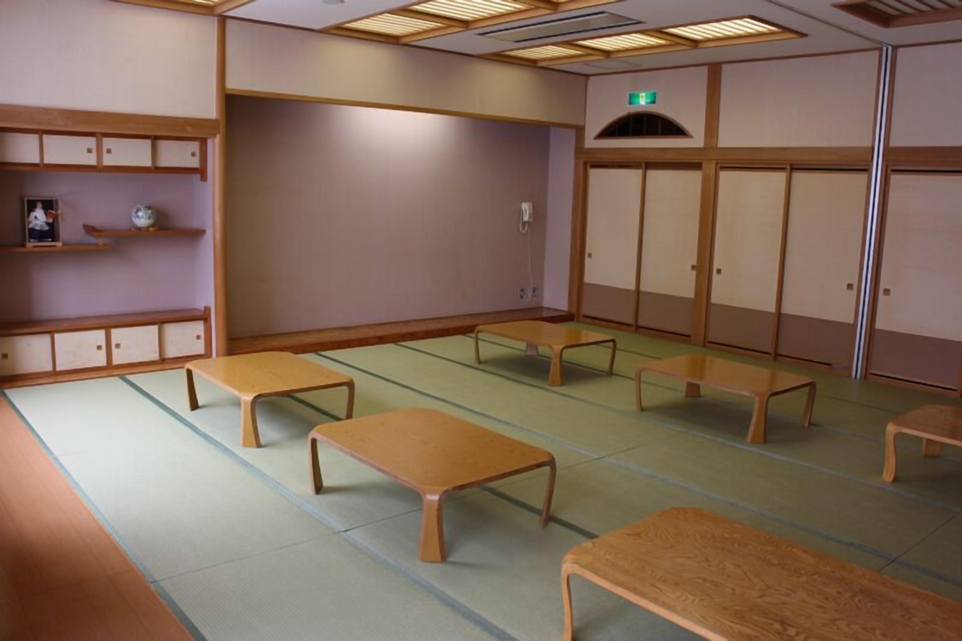 Een traditionele kamer met tatami matten, houten banken en een lage tafel.