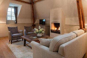 A cozy living room with a fireplace, a television, and comfortable seating.