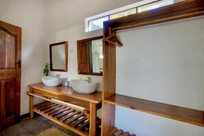 A bathroom with two wooden sinks, a mirror, and a wooden shelf. - Kamunjila Lodge (Livingstone)