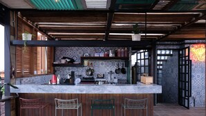 Una cocina con encimera de mármol, taburetes de bar de madera y una variedad de utensilios y electrodomésticos.