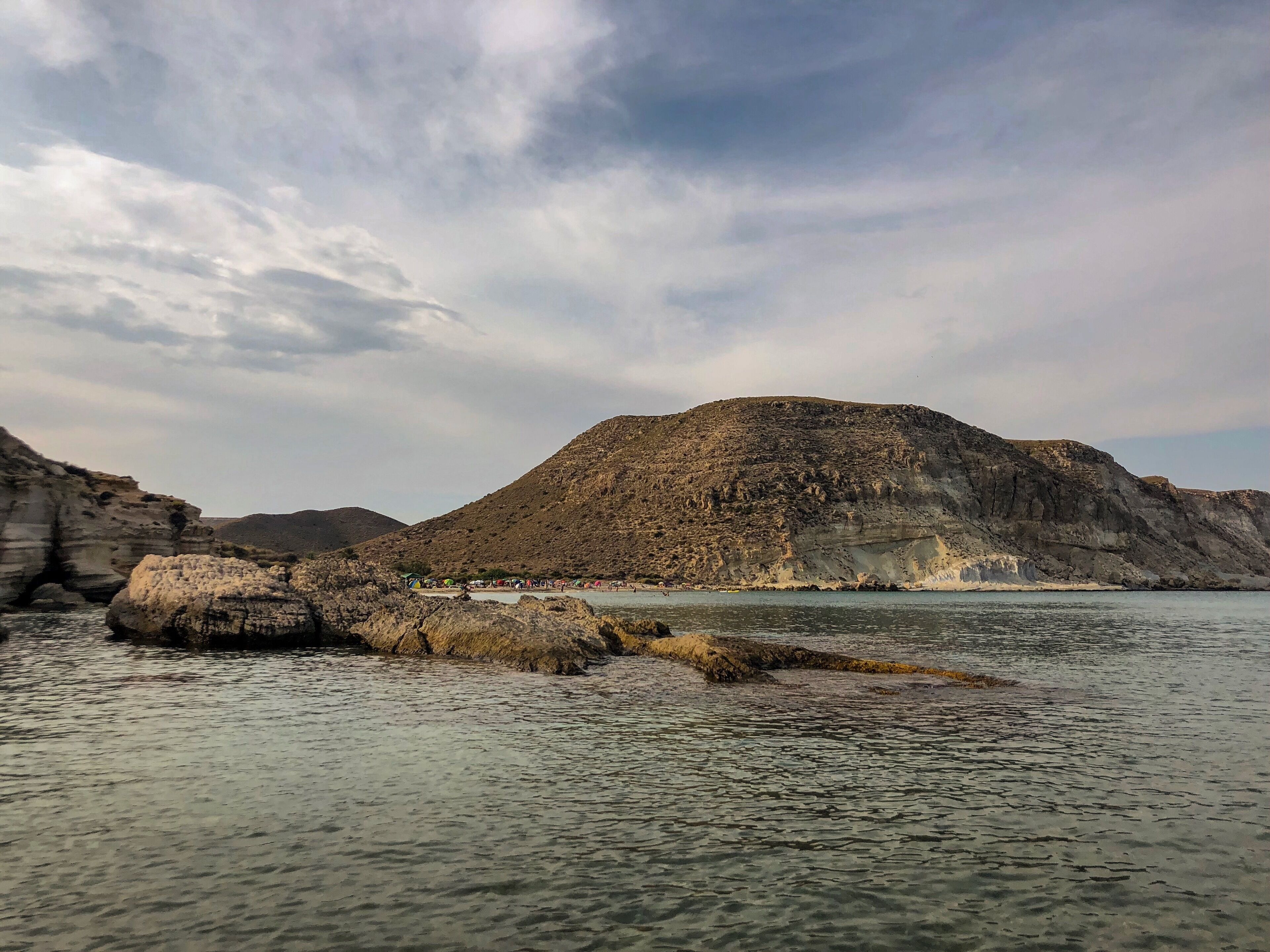 A coastal landscape with rocky formations and calm waters.