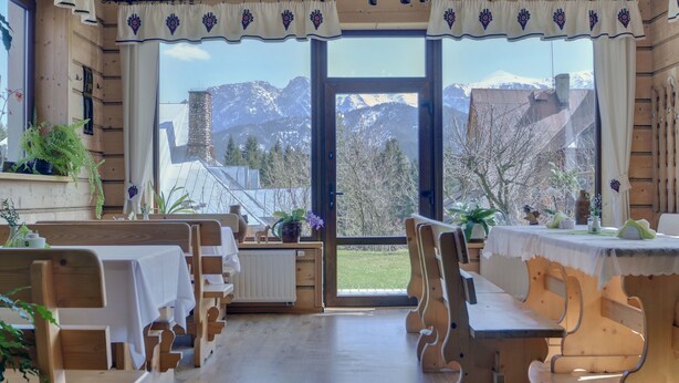 Un interior de madera con vistas a montañas a través de amplios ventanales.