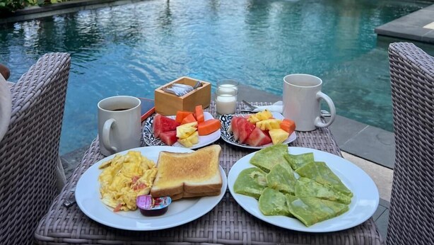 Frühstück am Pool in tropischer Umgebung.