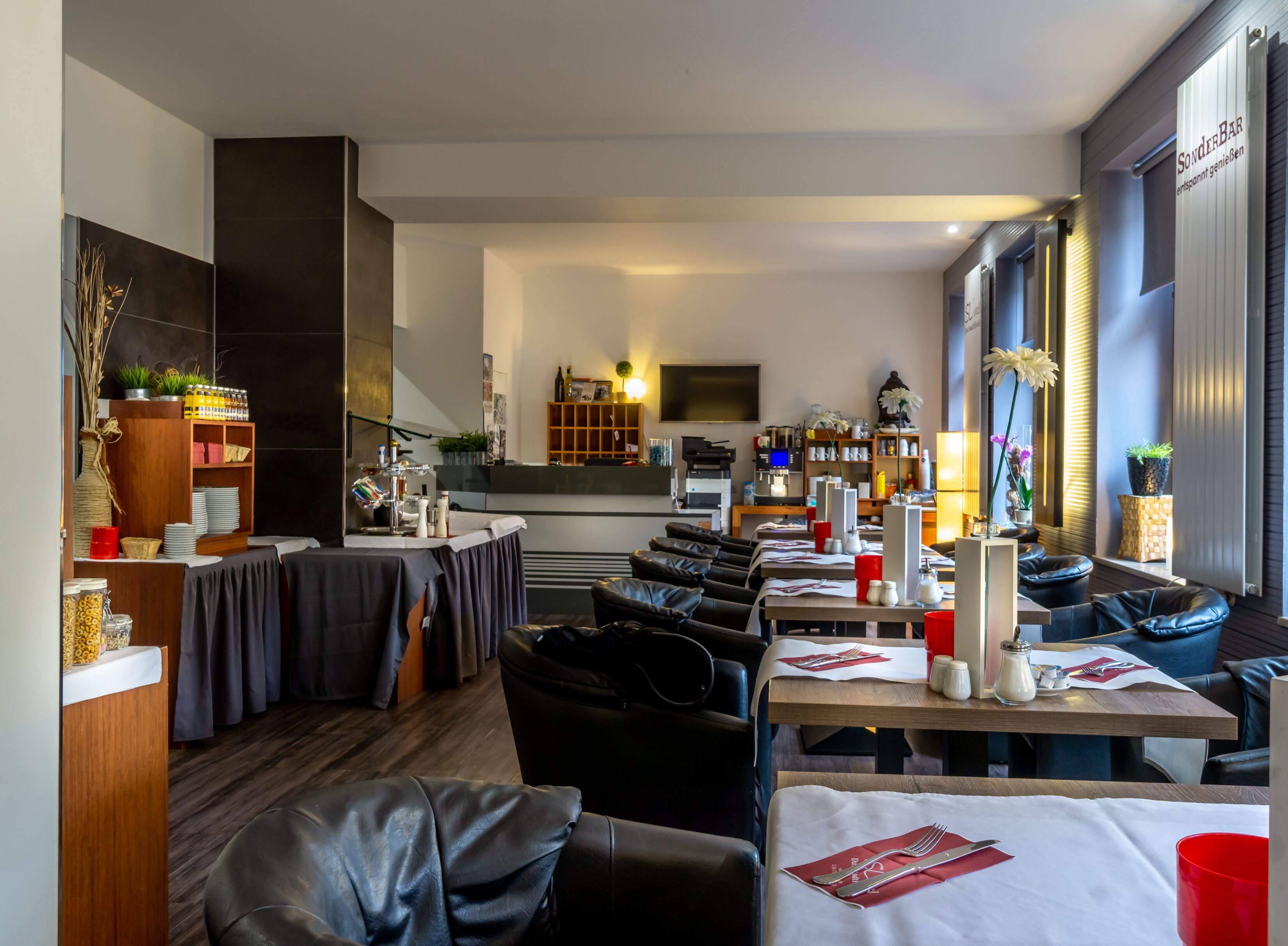 A restaurant with multiple tables, some with red cups, and a bar area with a counter and shelves.