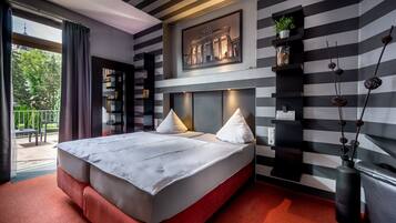 Een moderne hotelkamer met een groot bed, uitzicht op de omgeving en een gestreept wandontwerp.