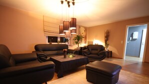 A modern living room with a sectional sofa, a coffee table, and a small side table. - SL'otel - Budget (Bernburg)