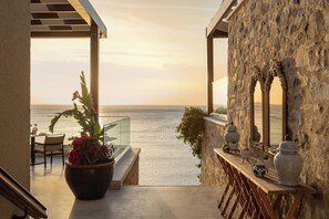A balcony with a view of the sea, a potted plant, and decorative vases. - Allium Bodrum Resort & Spa (Bodrum)