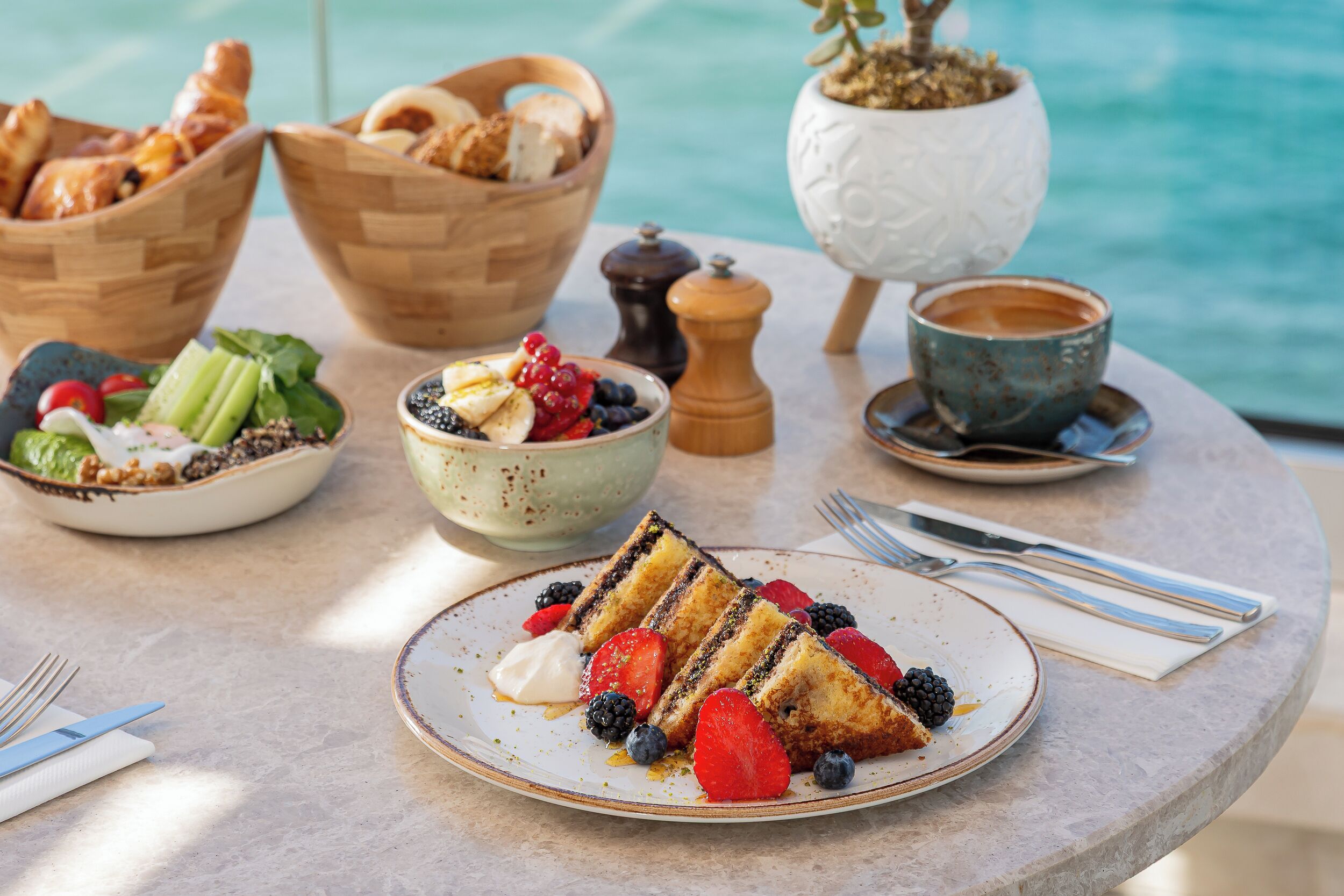 Ein Frühstücksbuffet mit Kuchen, Erdbeeren, Blaubeeren und einer Schale Obstsalat.