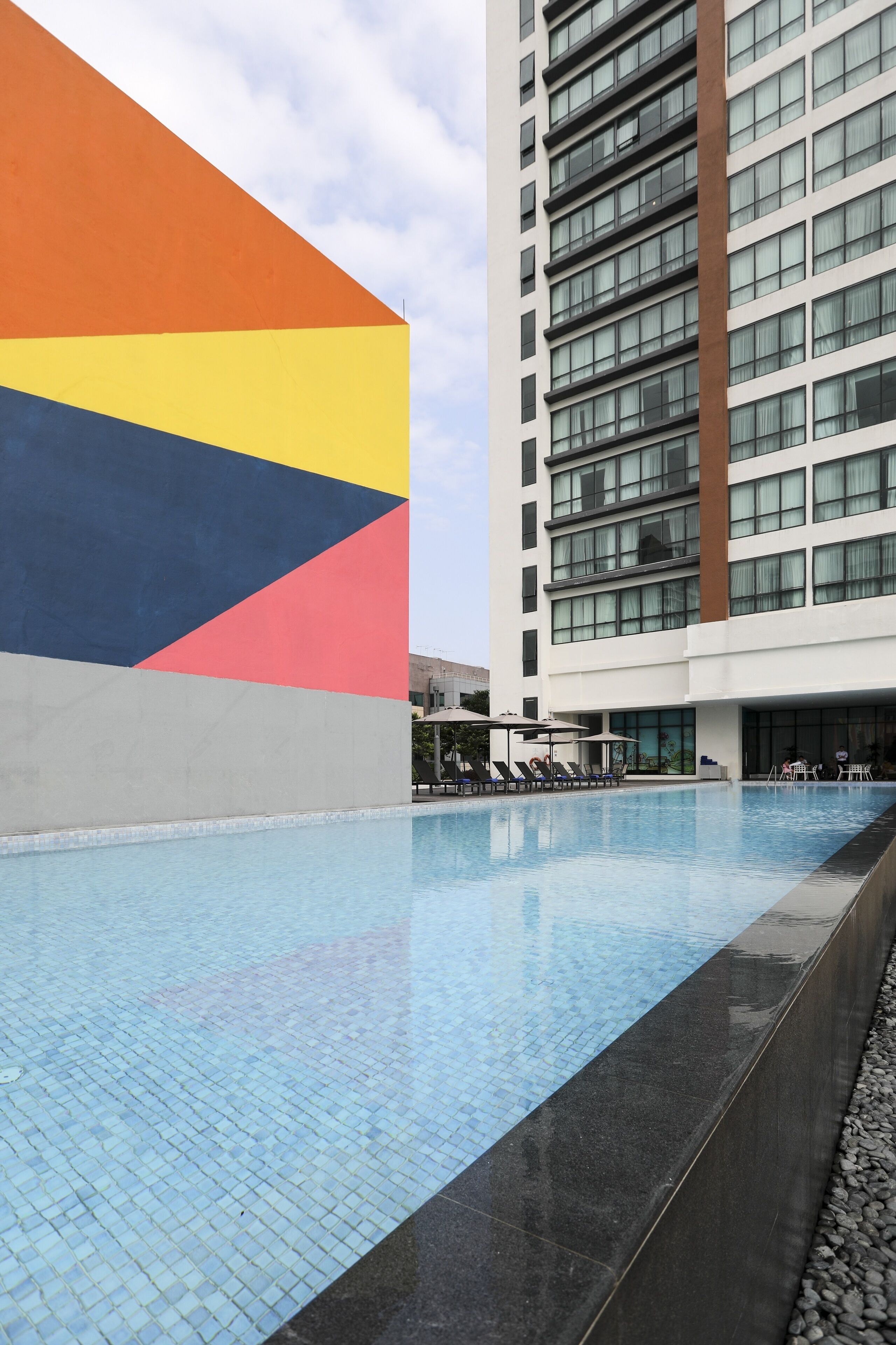 Una piscina al aire libre, sillones reclinables de piscina