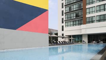 Una piscina al aire libre, tumbonas