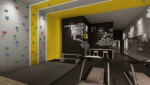 A modern interior with climbing walls, a seating area, and a wall with text and graphics. - Iway International Holiday Apartment (Guangzhou)