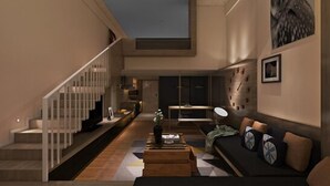 A modern living room with a staircase, a sofa, a coffee table, and a clock on the wall. - Iway International Holiday Apartment (Guangzhou)