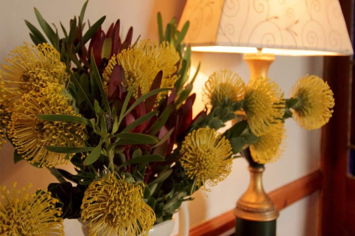 A bouquet of yellow flowers in a vase on a table.