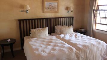 A hotel room with a large bed, two bedside tables, and a painting on the wall.