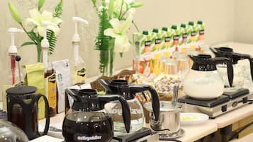 A coffee station with various coffee makers and a selection of beverages.