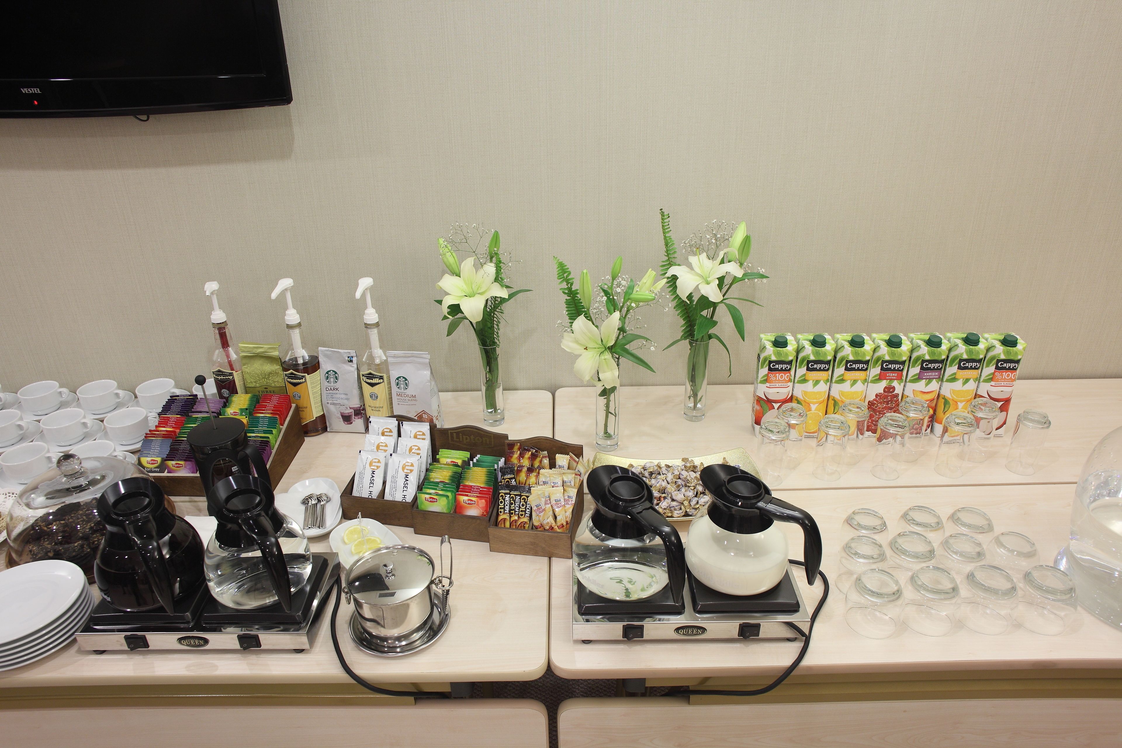A buffet setup with various food items, beverages, and a coffee station.