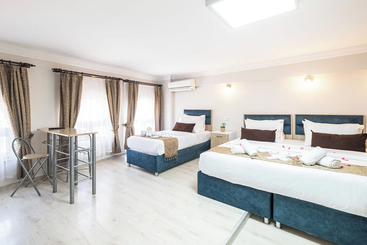 A hotel room with two beds, a desk, and a chair.