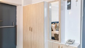 A room with a wardrobe, a mirror, and a telephone. - Oban Suites İstanbul (Istanbul)