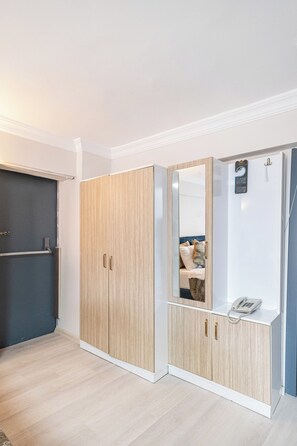 Una habitación con armario, espejo y teléfono.
