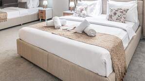 A modern hotel room with a large bed, two bedside tables, and a view of the city. - Oban Suites İstanbul (Istanbul)