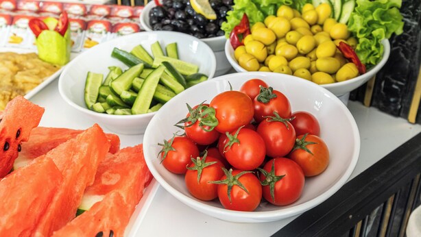 A table with various food items including tomatoes, cucumbers, olives, and lemons. - Oban Suites İstanbul (Istanbul)