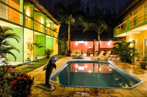 Relax by the pool surrounded by lush greenery and vibrant walls.