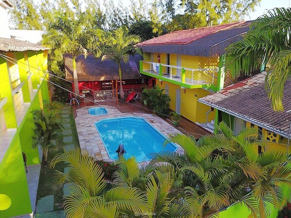 Relax by the serene pool surrounded by lush greenery and tropical palms.