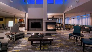 A spacious lobby with a fireplace, comfortable seating, and a high ceiling with skylights. - SpringHill Suites by Marriott Fishkill (Fishkill)
