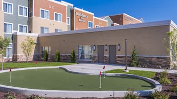 A hotel with a landscaped area featuring a putting green.