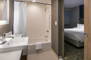 Um banheiro de hotel moderno com banheira, pia e chuveiro.