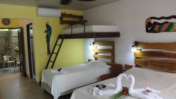 Habitación de hotel con dos camas, cabecero de madera, ventilador de techo y un adorno en la pared.