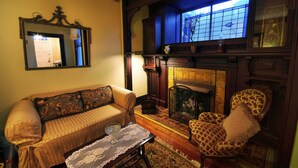 A cozy living room with a sofa, armchair, and a fireplace. - Vandiver Inn (Havre De Grace)