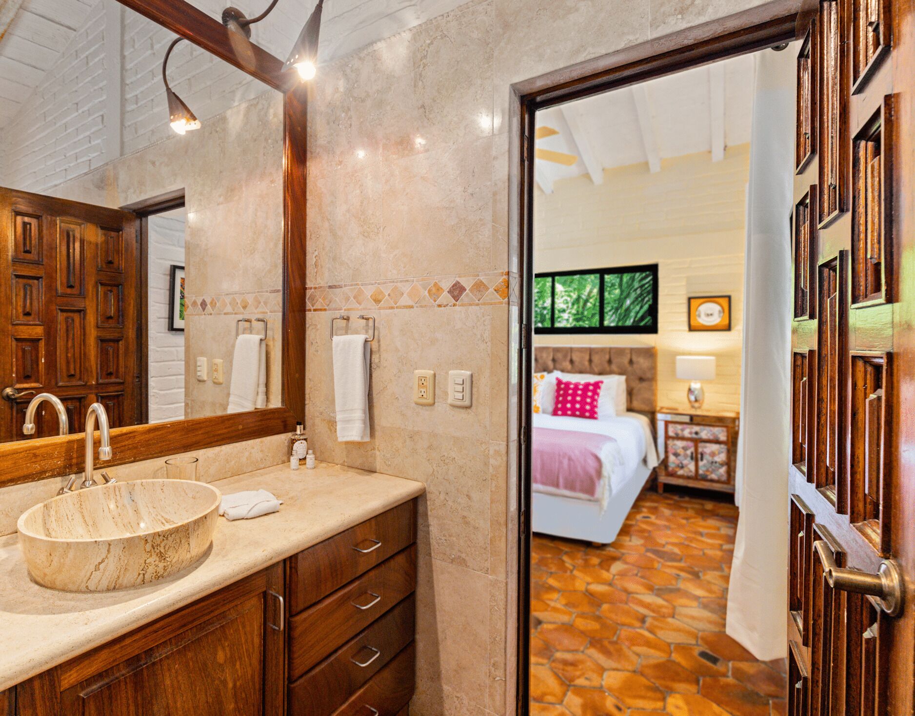 A bathroom with a wooden vanity, a round sink, and a mirror.