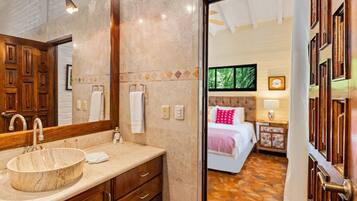 A bathroom with a wooden vanity, a round sink, and a mirror.
