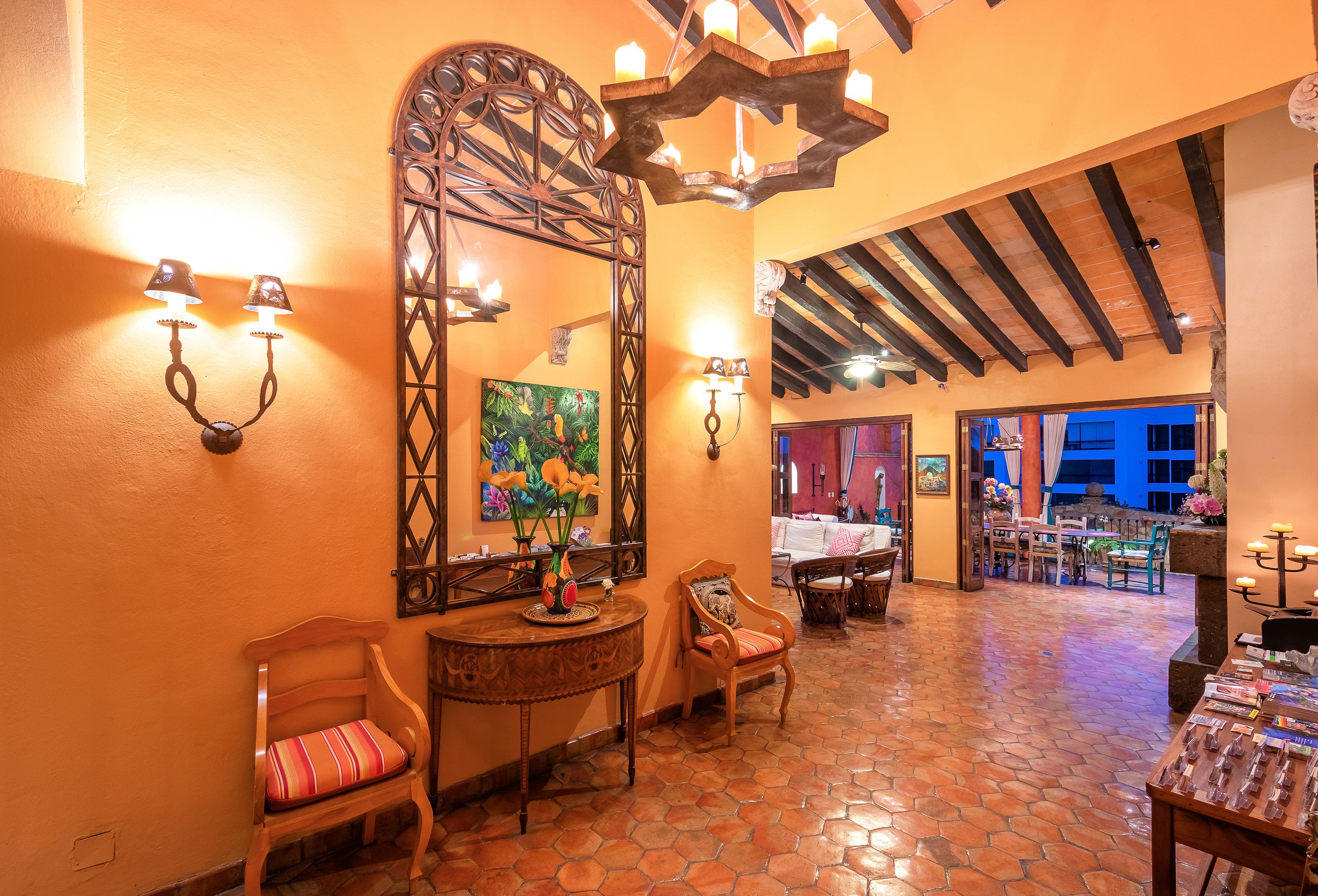 A cozy interior with a tiled floor, wooden furniture, and a large decorative mirror.