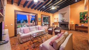 A cozy living room with a sofa, chairs, a coffee table, and a fireplace. - Villa Lola - an Adults Only Bed & Breakfast (Puerto Vallarta)