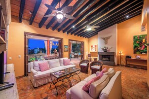 Una sala de estar acogedora con un sofá, sillones, una mesita de centro y una chimenea.
