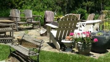 Relax in a serene outdoor space surrounded by lush greenery, perfect for dining or socializing with friends and family.